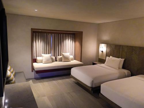 ein Hotelzimmer mit zwei Betten und einem Fenster in der Unterkunft Amorita Resort Palawan in Puerto Princesa