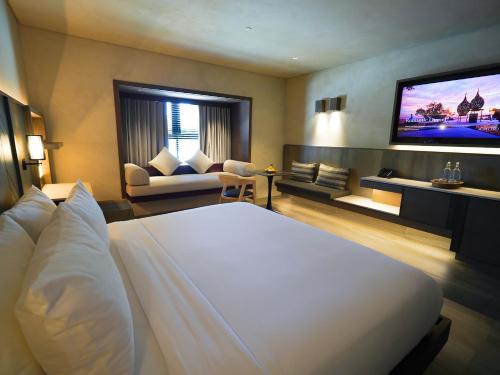 ein Hotelzimmer mit einem Bett und einem Fernseher in der Unterkunft Amorita Resort Palawan in Puerto Princesa