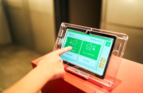 a person is using a tablet computer on a table at Rakuten STAY Osaka Station North Standard Fourth in Osaka