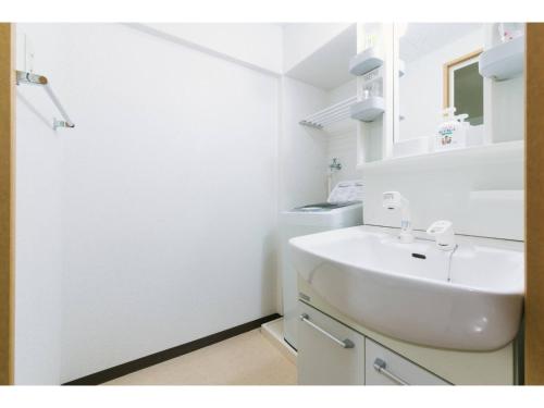 a white bathroom with a sink and a mirror at VIEW HAKATA - Vacation STAY 87980 in Fukuoka