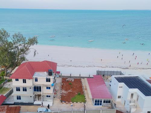 an aerial view of a beach with buildings and the ocean at Spacious Beachfront Condo -AC - WiFi, Uroa Escape Zanzibar in Uroa