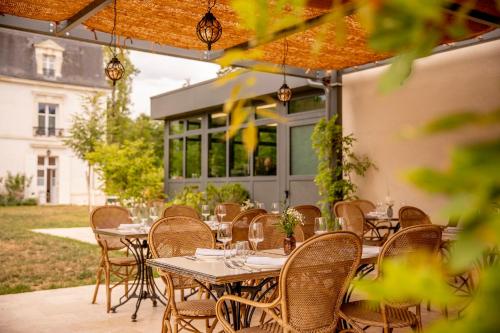 a group of tables and chairs on a patio at Les Hayes en Sologne in Fontaines-en-Sologne