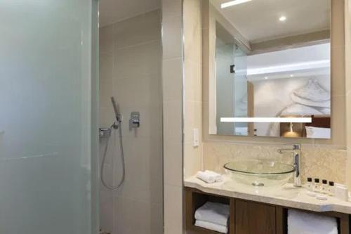 a bathroom with a glass sink and a shower at Mpilo Boutique Hotel in Maseru