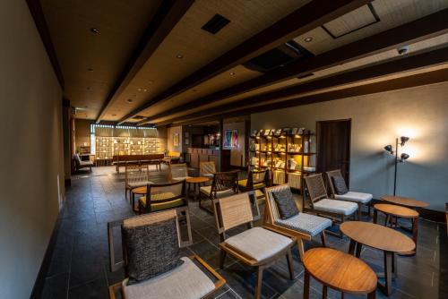 a library with chairs and tables and bookshelves at Temple Town Hotel WAQOO Horyuji in Ikaruga