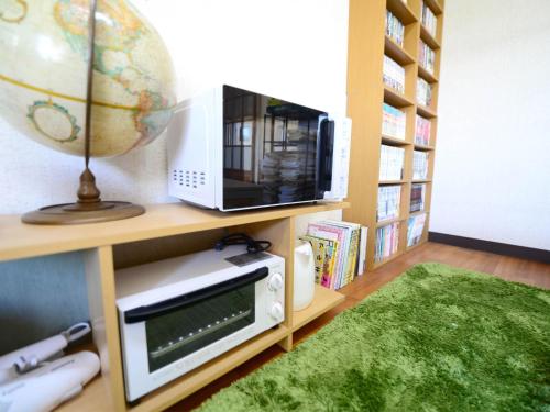 a room with a microwave and a television on a shelf at Kochi - House - Vacation STAY 88439 in Kochi