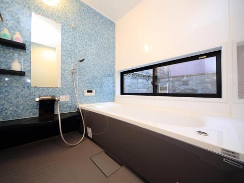 a bathroom with a large bath tub with a window at Fushimi - House - Vacation STAY 88668 in Fushimi