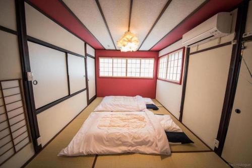 a bedroom with a bed in a room with windows at Fushimi - House - Vacation STAY 88668 in Fushimi