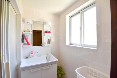a white bathroom with a sink and a mirror at Nago - House - Vacation STAY 88505 in Nago