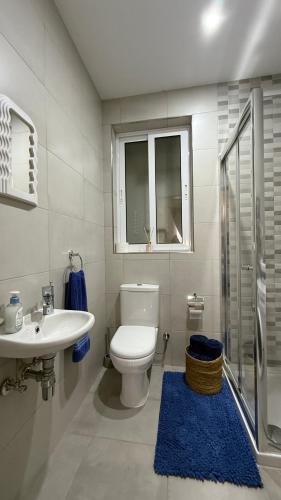 a white bathroom with a toilet and a sink at Seabreeze Marsaxlokk Apartment in Marsaxlokk