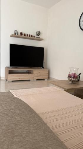 a living room with a flat screen tv on a stand at Seabreeze Marsaxlokk Apartment in Marsaxlokk
