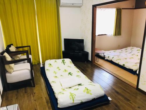 a room with two beds and a tv and a mirror at It's Town Kasuga B Building - Vacation STAY 89474 in Kasuga