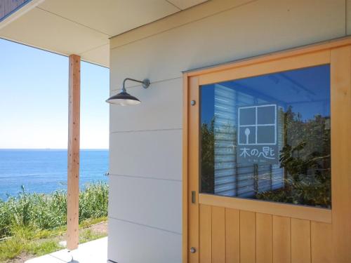 a door to a house with the ocean in the background at Kino-saji - Vacation STAY 89208 in Ibusuki