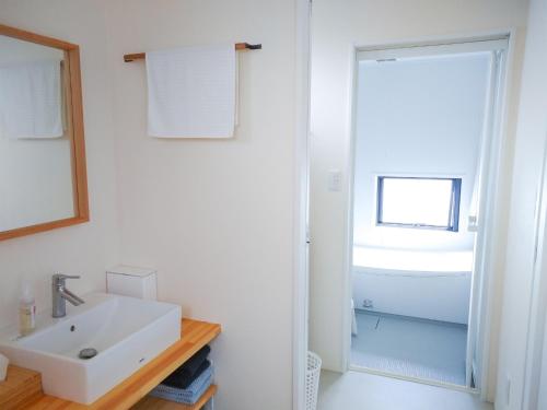 a white bathroom with a sink and a mirror at Kino-saji - Vacation STAY 89208 in Ibusuki