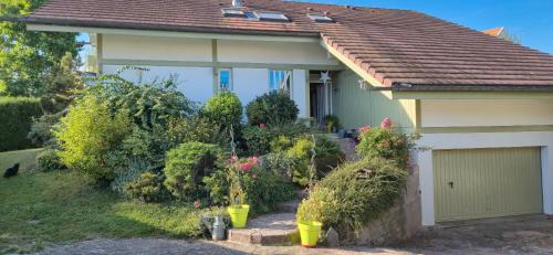 a house with flowers and plants in front of it at Chambre d'hôte - La Maison Verte in Charmes