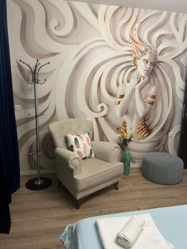 a room with a chair and a woman on a wall at Sandanski Apartments Top Center in Sandanski
