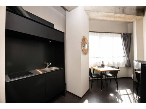a kitchen with a sink and a table with chairs at Volcano - Vacation STAY 89669 in Kagoshima