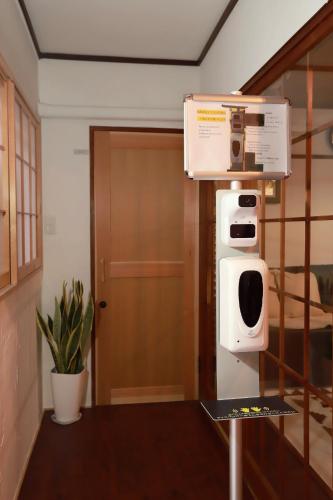 a microwave on a stand in a room with a door at Kyo KOZO Kitano Tenjin - Vacation STAY 89906 in Kyoto