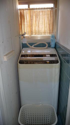 a small washing machine in a small room with a window at Guesthouse Yadokari - Vacation STAY 90101 in Imabari
