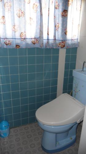 a bathroom with a toilet and a blue tiled wall at Guesthouse Yadokari - Vacation STAY 90101 in Imabari