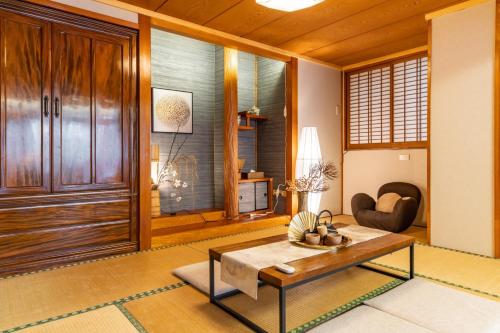 ein Wohnzimmer mit einer Holztür und einem Tisch in der Unterkunft ASAHI HOUSE 2nd floor - Vacation STAY 92767 in Naha