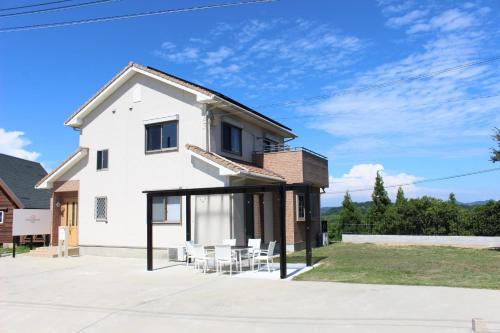 a white house with black windows and chairs at Sumoto - House - Vacation STAY 91396 in Sumoto