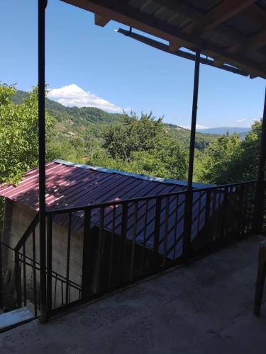 a view of the mountains from the porch of a house at Lusa Guesthouse in Nikortsminda
