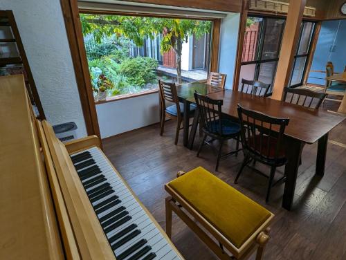 a dining room with a piano and a table and chairs at guest house Ki-zu - Vacation STAY 92940 in Nishio
