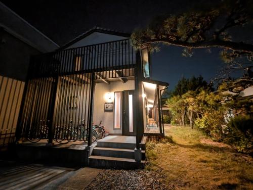 a house with stairs and a porch at night at guest house Ki-zu - Vacation STAY 92940 in Nishio