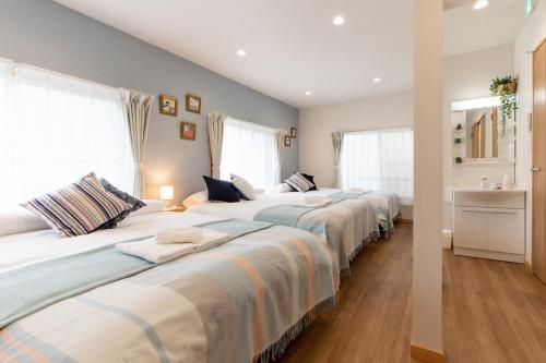 zwei Betten in einem Zimmer mit zwei Fenstern in der Unterkunft TK Court Ojima - Vacation STAY 91237 in Tokio