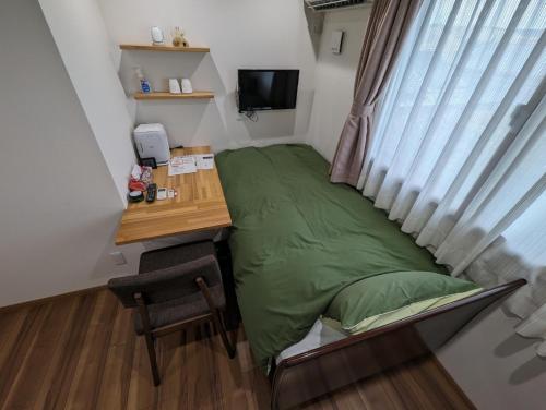 a bedroom with a bed and a desk and a window at guest house Ki-zu - Vacation STAY 94978v in Nishio