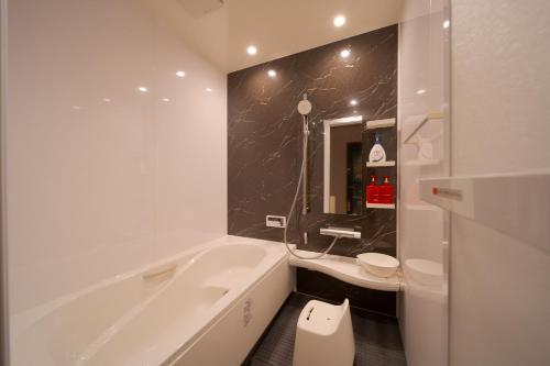 a white bathroom with a tub and a sink at Takanoya Kumo - Vacation STAY 91939 in Yufuin