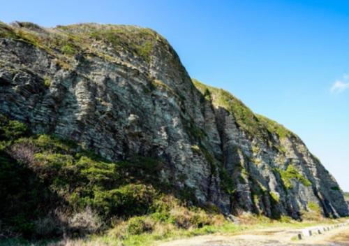 a large rock with grass on it next to a road at Iruka House 1 - Vacation STAY 9266 in Iki