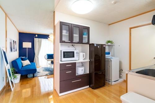 una cocina con nevera y microondas en ASAHI HOUSE 2nd floor - Vacation STAY 92770, en Naha
