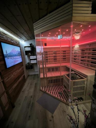 a large bird cage in a room with red lights at Haus Blindauer Eck in Reit im Winkl