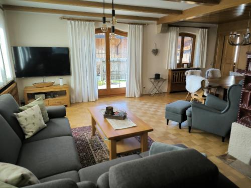 a living room with a couch and a table at Haus Blindauer Eck in Reit im Winkl
