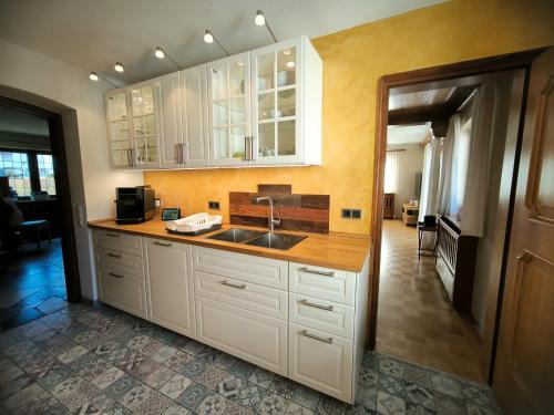 a kitchen with white cabinets and a sink at Haus Blindauer Eck in Reit im Winkl