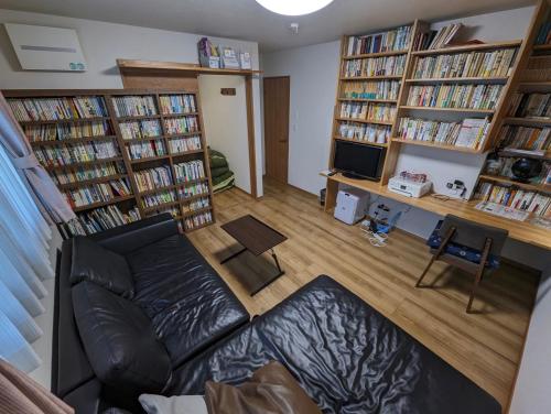 a living room with a couch and several book shelves at guest house Ki-zu - Vacation STAY 95389v in Nishio