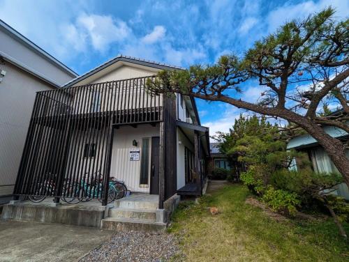 a house with a black fence next to a tree at guest house Ki-zu - Vacation STAY 95389v in Nishio