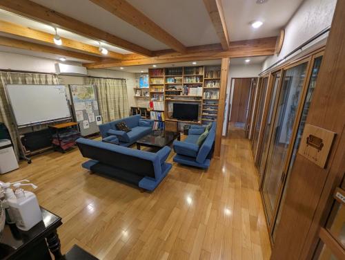 a living room with two blue couches and a tv at guest house Ki-zu - Vacation STAY 95389v in Nishio