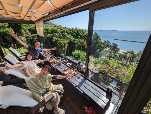 a group of people sitting at a table on a balcony at guest house Ki-zu - Vacation STAY 95389v in Nishio
