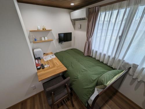 a small room with a desk and a green bed at guest house Ki-zu - Vacation STAY 96116v in Nishio