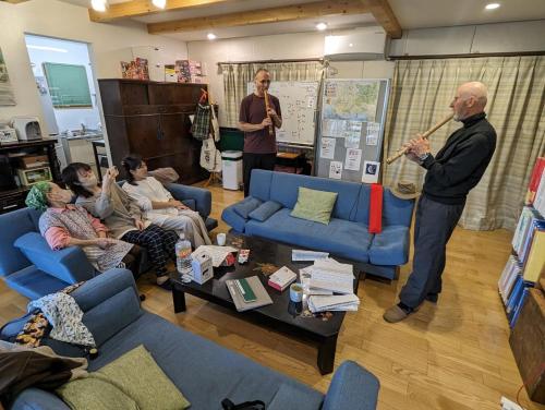 a man playing instruments in a living room with people at guest house Ki-zu - Vacation STAY 96116v in Nishio