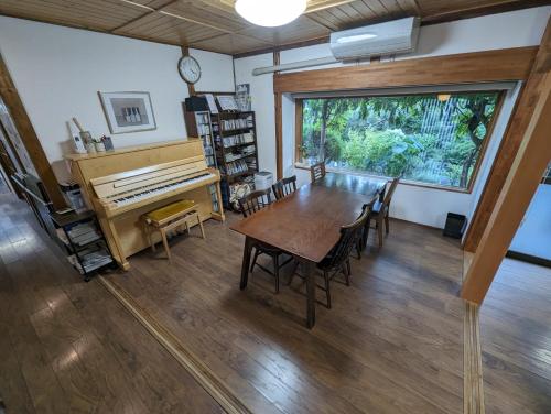 a dining room with a table and a piano at guest house Ki-zu - Vacation STAY 96116v in Nishio