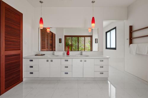 a white bathroom with two sinks and a mirror at Sila Ananda 6BR Pool Villa Đảo Xanh Đà Nẵng in Da Nang