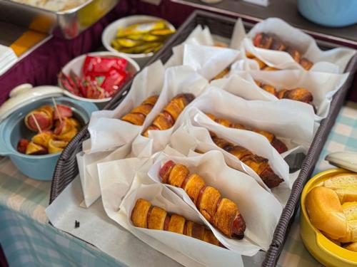 a table topped with trays of hot dogs and other foods at Hotel Skypark Myeongdong 1 in Seoul