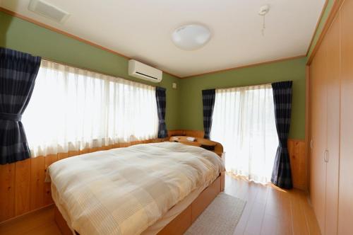 a bedroom with a bed with green walls and windows at Omoritei - Vacation STAY 9265 in Nasushiobara
