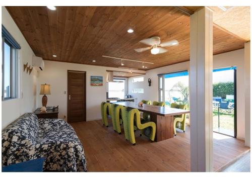 a bedroom with a bed and a table with yellow chairs at Beach Front House Suzuka - Vacation STAY 9364 in Suzuka