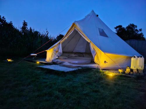 a white and yellow tent in a field at night at Glamping Gozdna jagoda in Šmartno pod Šmarno Goro