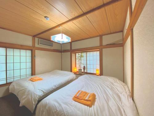 two beds in a room with wooden ceilings and windows at Yuzawa Toyo - Vacation STAY 98053 in Yuzawa