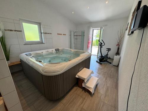 a large bath tub in a bathroom with a television at Villa ISA 4 bedrooms, 4 bathrooms, sauna, jacuzzi, panoramic view in Vrh